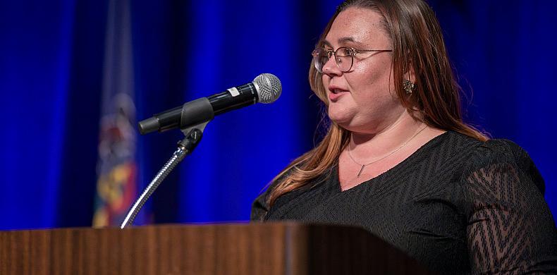 Ashlie Crosson '11 speaks behind a podium